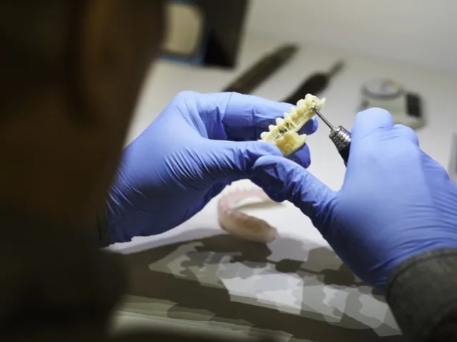 Fogtechnikus 3D nyomtatott fogmodellt fejez be közelről