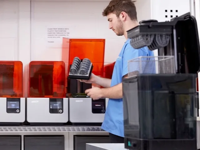 Fogtechnikus 3D nyomtatott fogmodelleket vesz ki a nyomtatóból